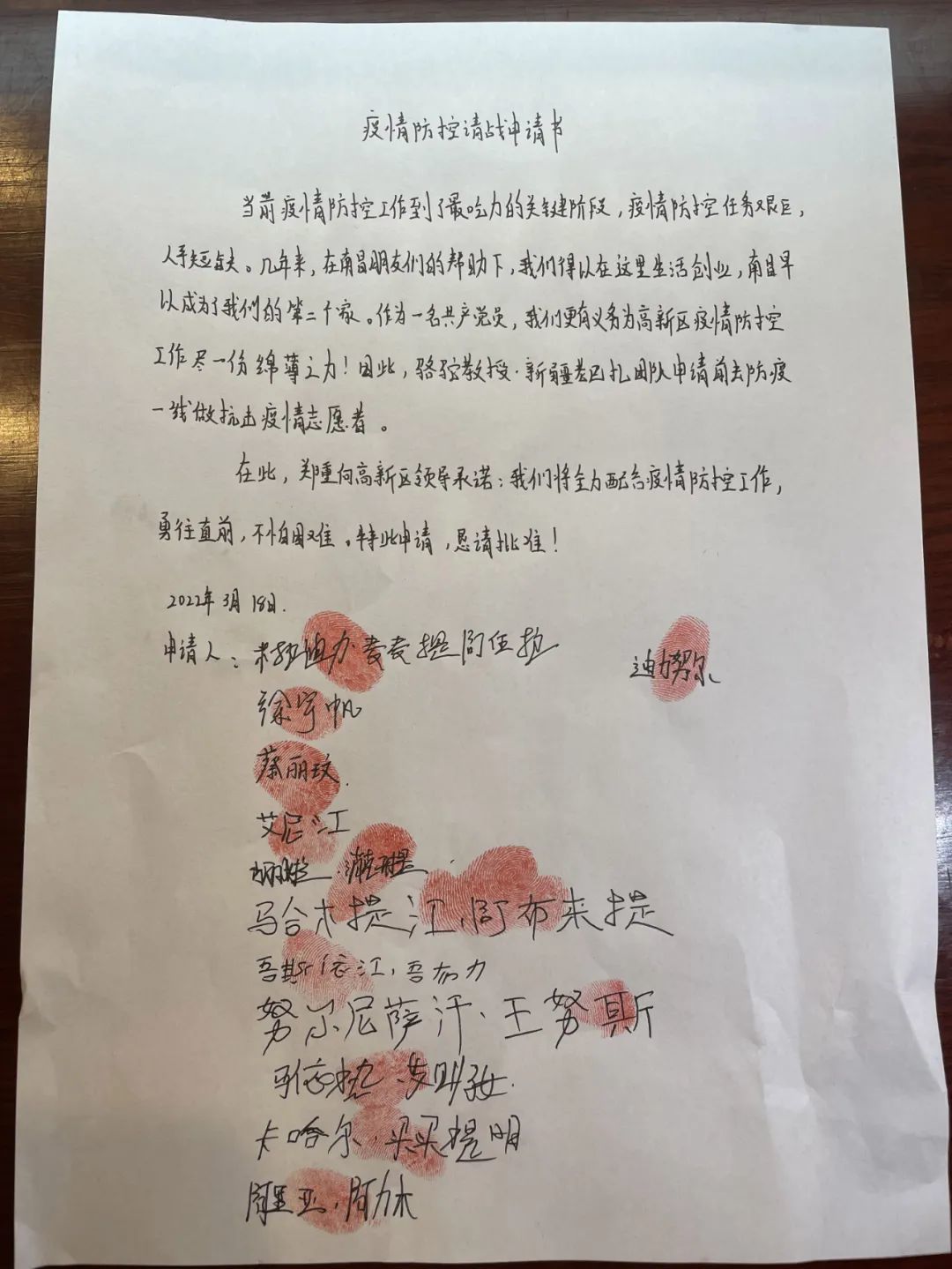↑米拉迪力和团队成员写下疫情防控请战申请书。(受访者供图)