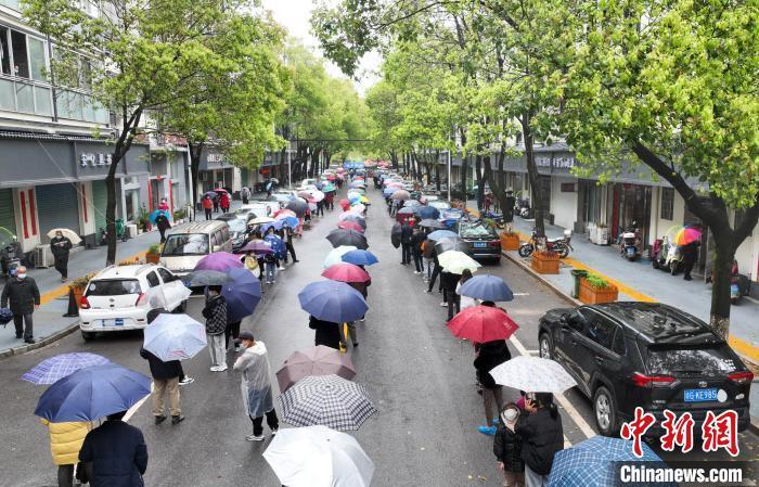 3月25日，江西省瑞昌市城区核酸检测点，市民冒雨排队接受第三轮核酸检测。　魏东升 摄