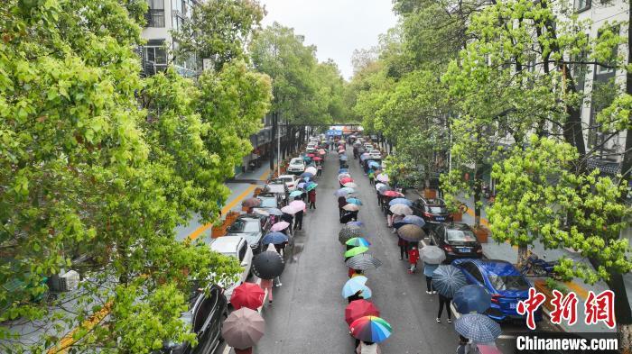 3月25日，江西省瑞昌市城区核酸检测点，市民冒雨排队接受第三轮核酸检测。　魏东升 摄