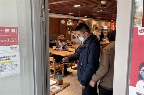 市民在餐馆门口扫码测温/来自1039调查团