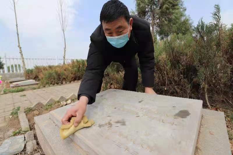 村民在擦拭烈士墓碑。