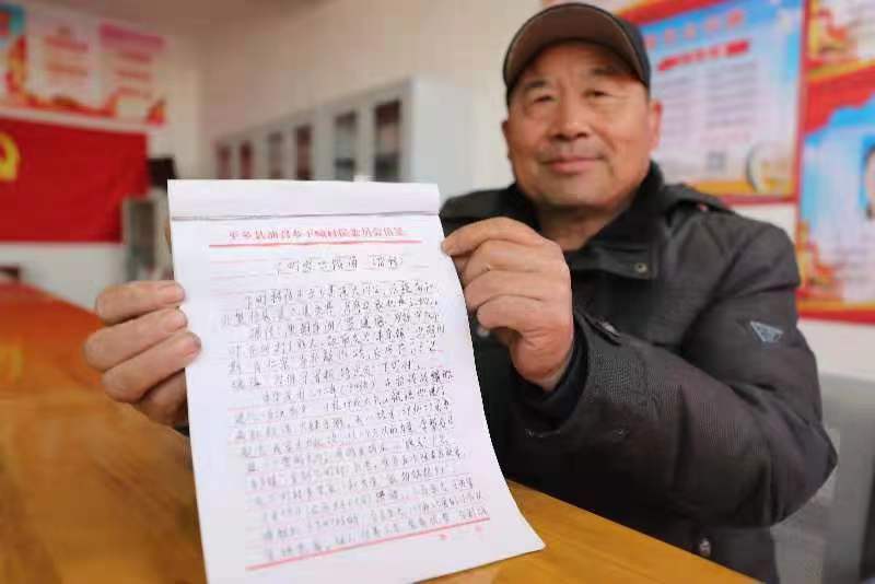 赵尽杰展示自己整理的十八烈士事迹材料。