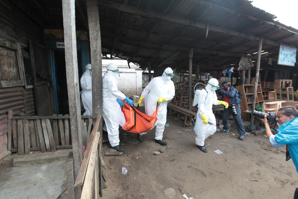 在利比里亚首都蒙罗维亚,工作人员将感染埃博拉病毒死亡者的尸体带离
