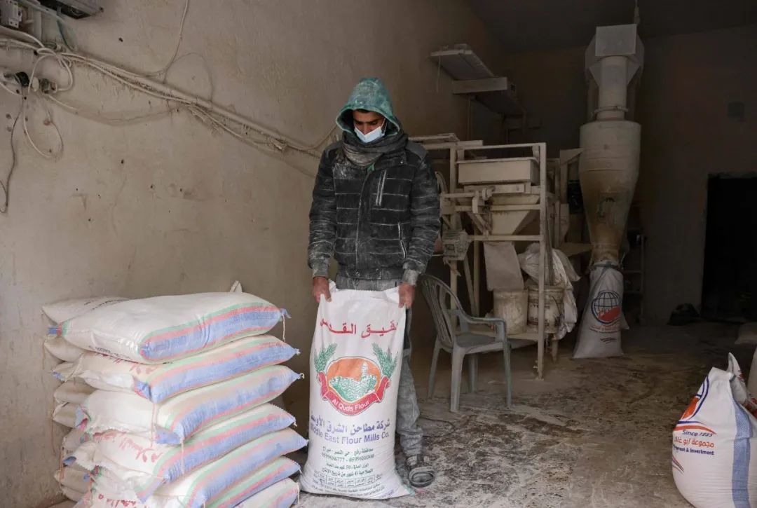 一名巴勒斯坦工人在加沙地带南部拉法的一家小麦厂工作。俄罗斯出兵乌克兰可能意味着阿拉伯世界许多国家的餐桌上的面包减少，数百万人已经在为生存而苦苦挣扎