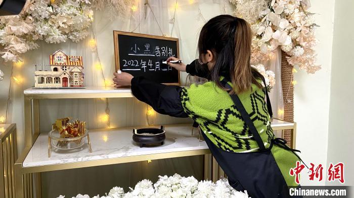 “90后”宠物殡葬师在小黑板上写上宠物名字。　孙婷婷 摄