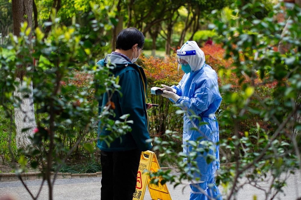 2022年4月4日上午，医护人员扫描登记居民的二维码。