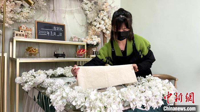 “90后”宠物殡葬师为宠物盖上白布。　孙婷婷 摄