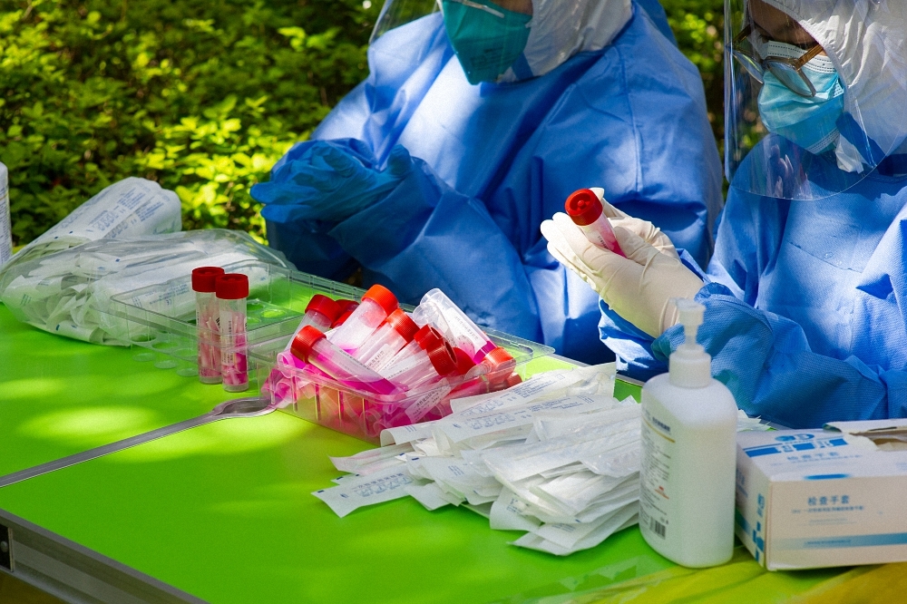 2022年4月4日上午，医护人员为核酸采样管贴标签。