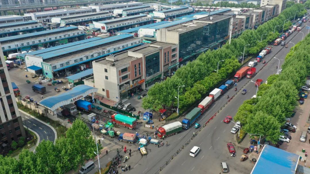 合肥周谷堆農產品批發市場外,貨車在交警的指揮下,有序入園.