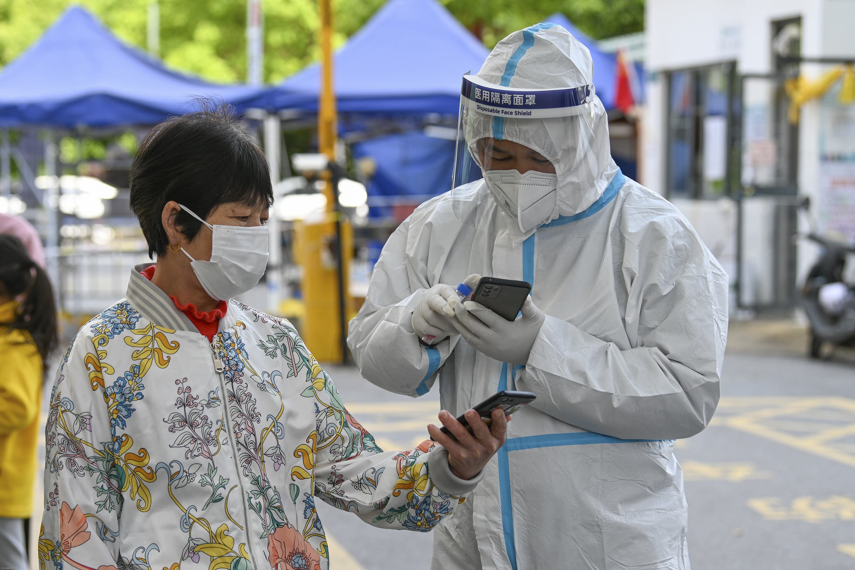 2022年4月18日,上海闵行某小区,志愿者老俞给核酸检测的居民扫码.