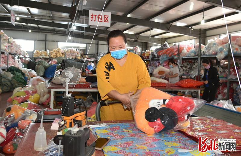 4月22日，容城县轻纺城世纪熊玩具馆打包区，工人正在将毛绒玩具打包装入快递袋。 河北日报记者赵海江摄