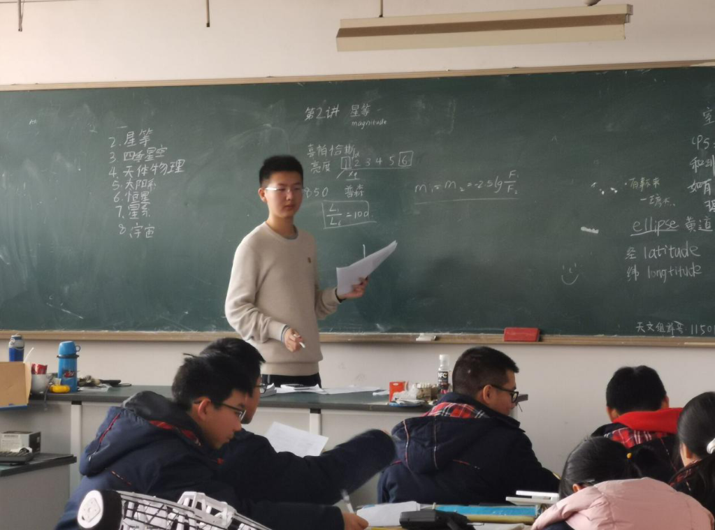 图为熊家锐在教室和同学讨论问题