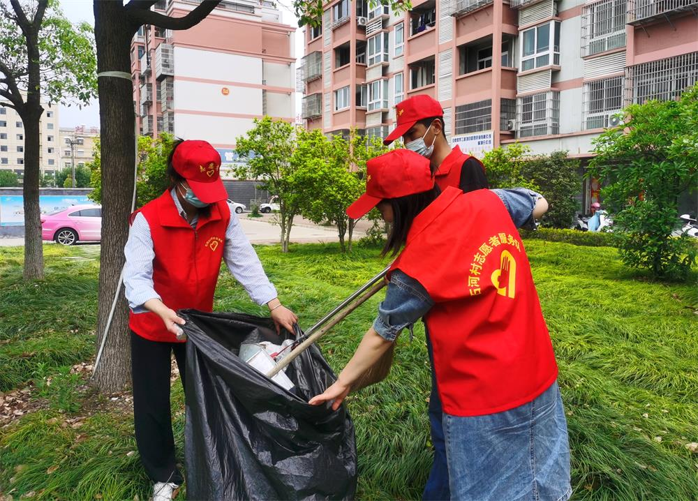 图为石河村新时代文明实践站组织志愿者清理绿化带垃圾