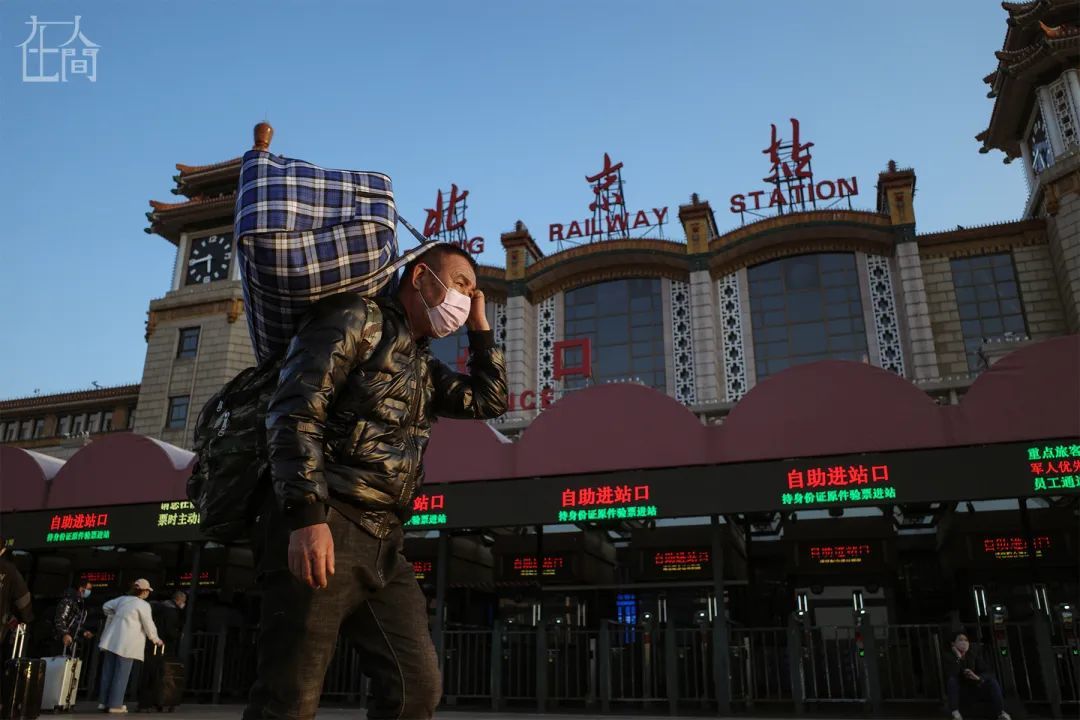 ▲ 3月17日，北京站，扛着行李、戴着口罩的返京务工者。