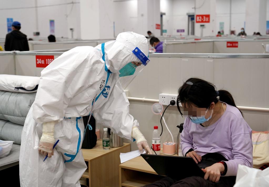 4月21日，上海市临港方舱医院内的医护人员与患者交流。新华社记者 杨有宗 摄