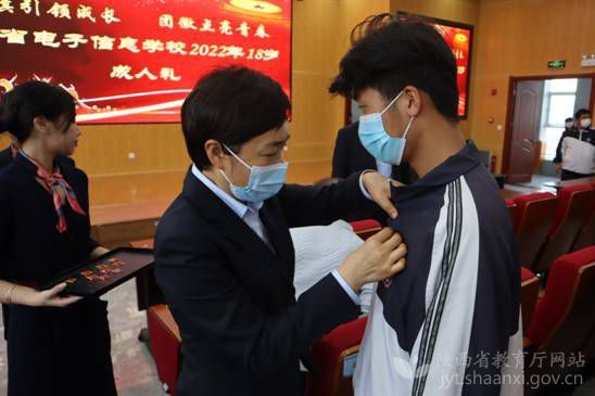 陕西省电子信息学校校长魏萍为参加成人礼学生佩戴徽章