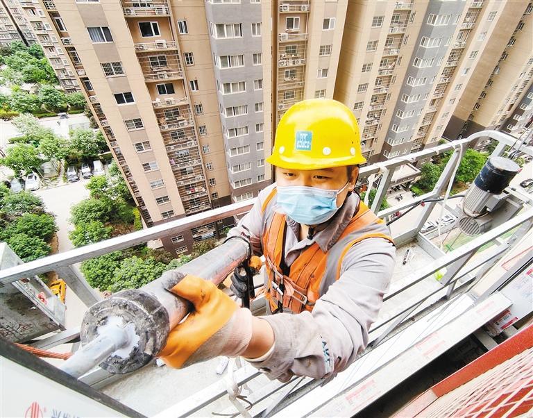 安装工肖尧在高空吊篮上进行作业。