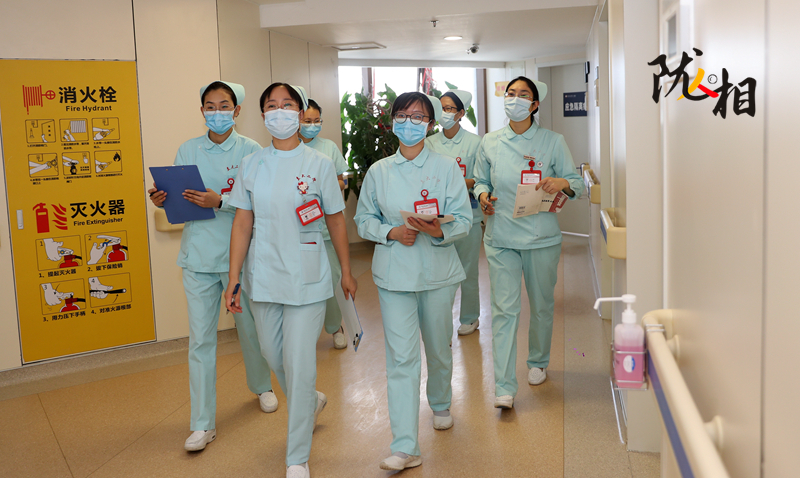 王兴蕾（中）与护士们查房交接工作