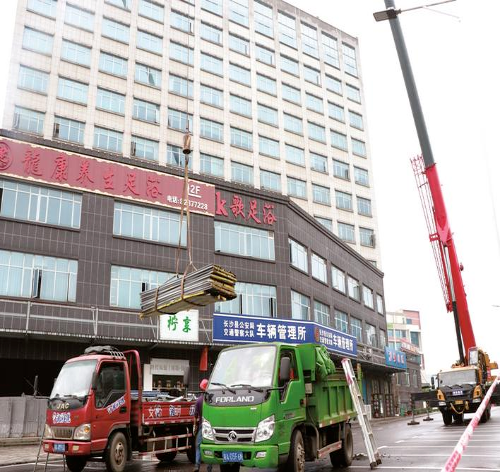 5月8日，在长沙县长龙街道云朵酒店前坪，工作人员吊装清运建筑垃圾。 林畅 摄