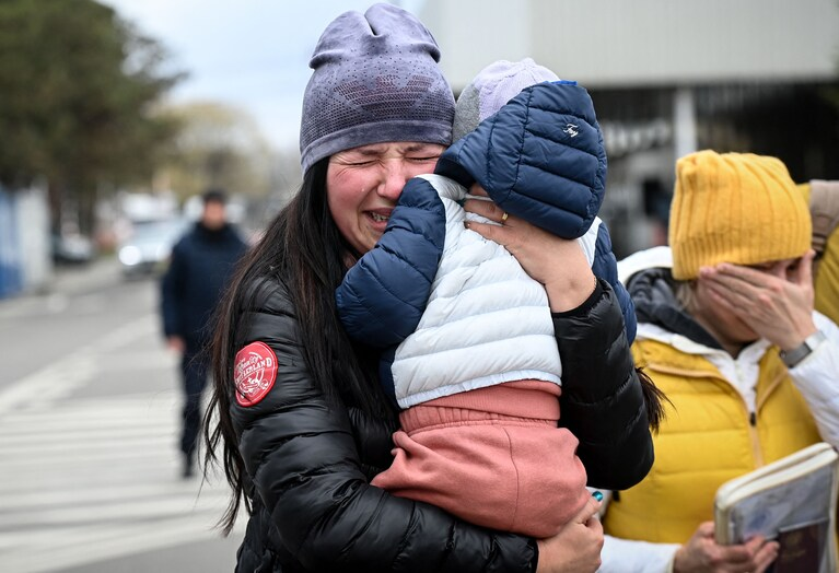 2022 年 4 月 18 日，一名抱着孩子的乌克兰难民在抵达罗马尼亚和乌克兰之间的 Siret 过境点后哭泣。