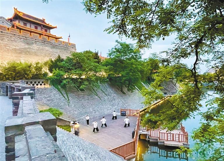 市民在护城河边练习太极拳。 （记者 王旭东 摄 资料图片）