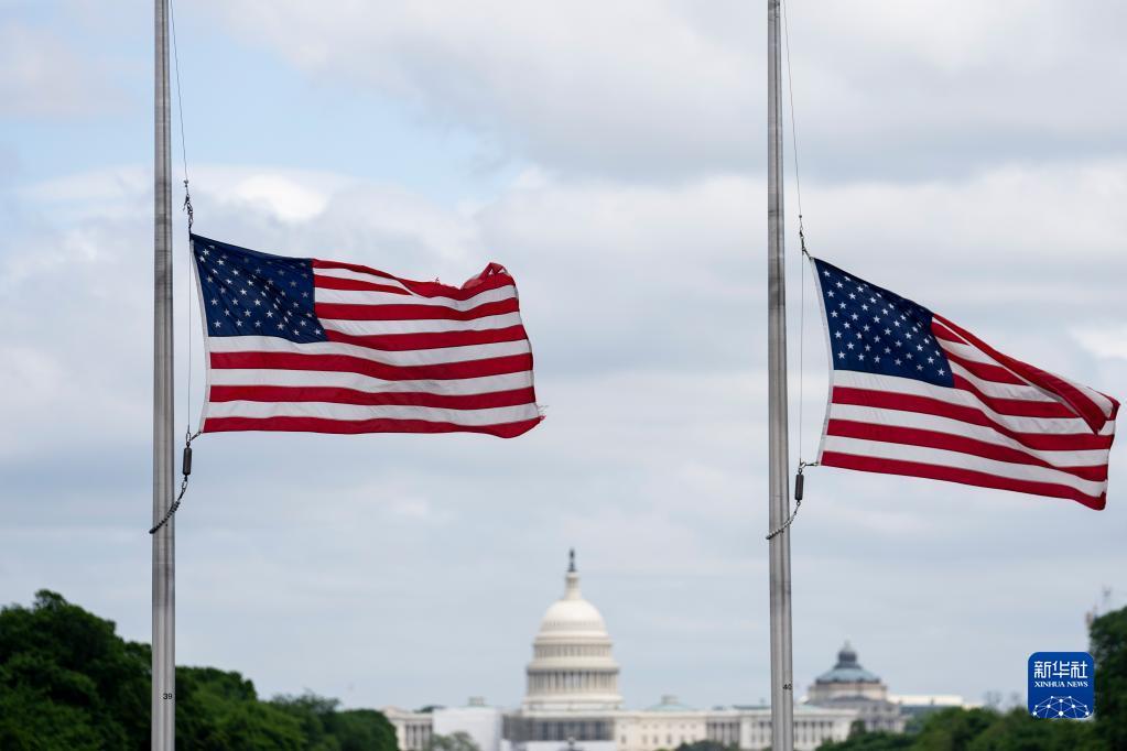 5月12日，在美国华盛顿，华盛顿纪念碑周围的美国国旗降半旗悼念新冠逝者。新华社记者刘杰摄