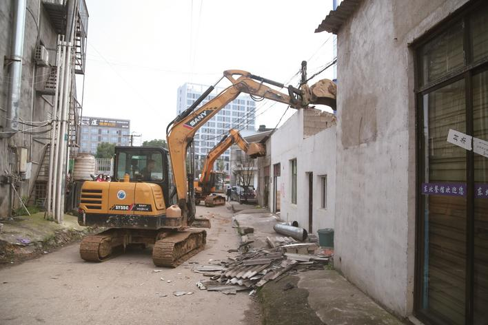 两台挖掘机同时出动，拆除黄兴镇打卦岭村海吉星市场周边违建房屋。陈晨 摄