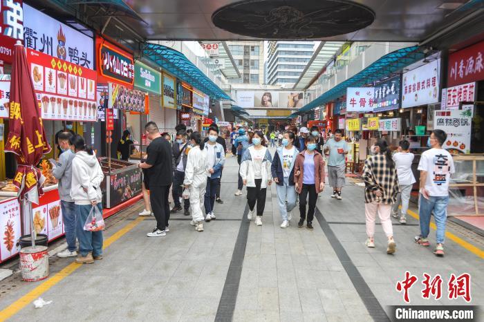 图为江西南昌一美食街，不少市民在逛街品尝美食。　刘力鑫 摄