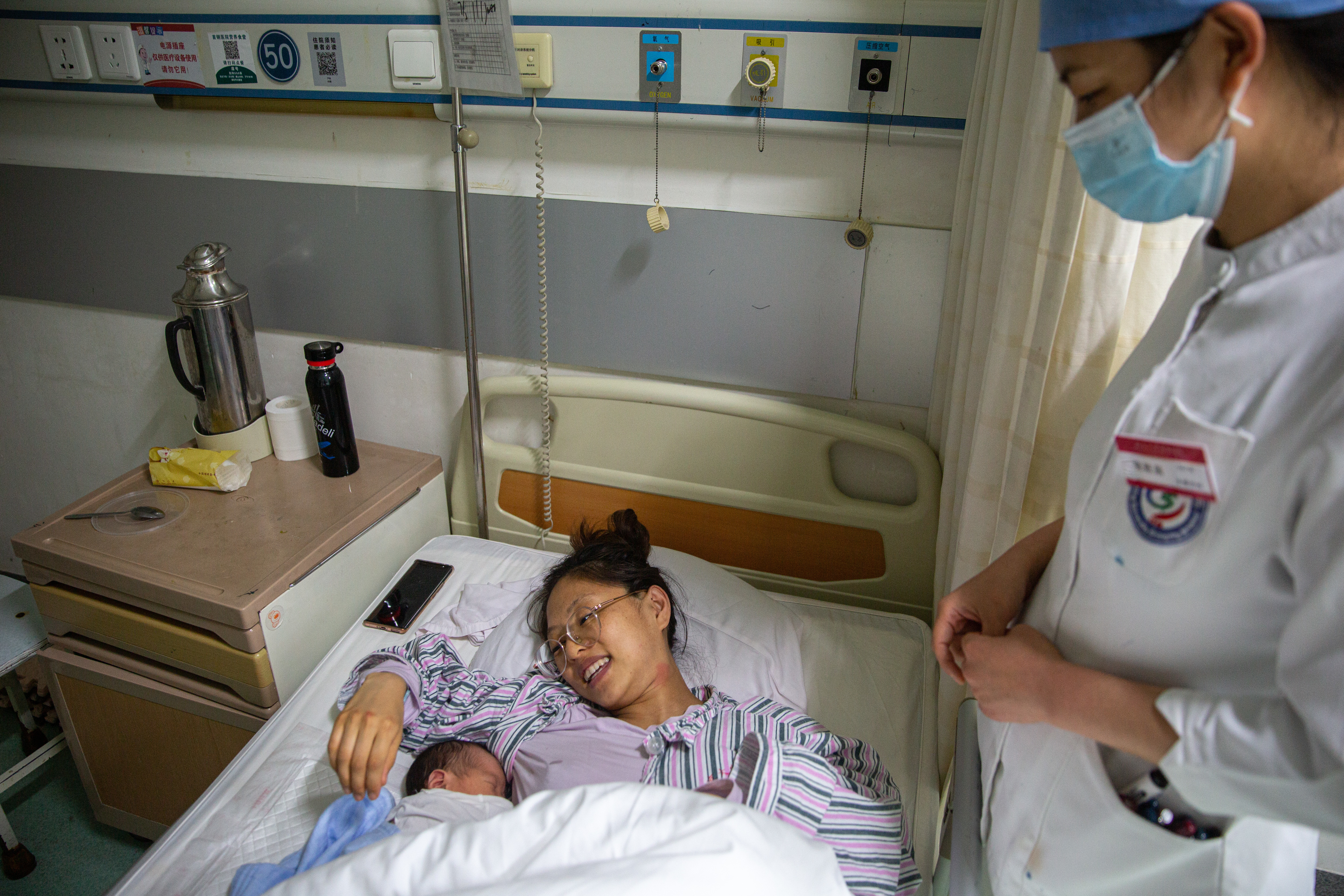 5月7日晚，北京大学首钢医院产科病房，护士张胜苗与年轻妈妈聊天。