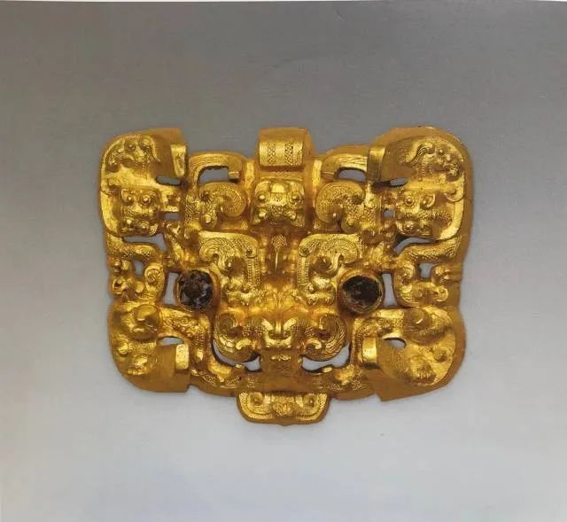 高浮雕兽面纹金带扣。战国晚期（公元前300年—前221年）甘肃省文物考古研究所藏。此器物具有中原华夏与边陲戎狄两种艺术风格。