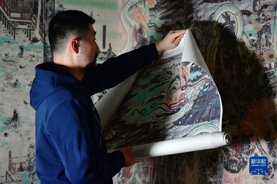 4月19日，在莫高窟第172窟，劉小同在對比臨摹壁畫的細節。新華社記者 陳斌 攝