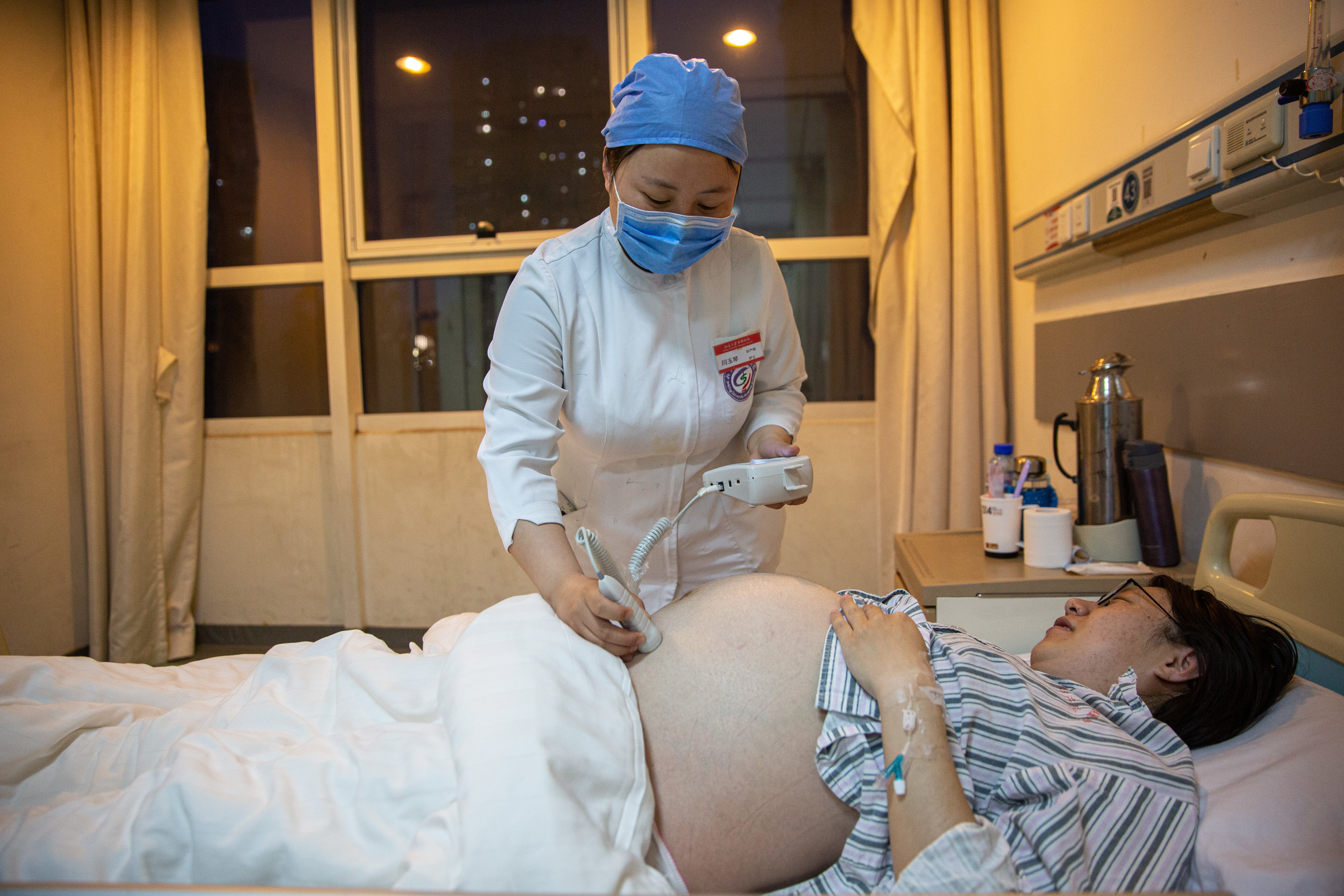 5月7日晚，北京大学首钢医院产科病房，护士闫玉琴为一名孕妇听胎心。