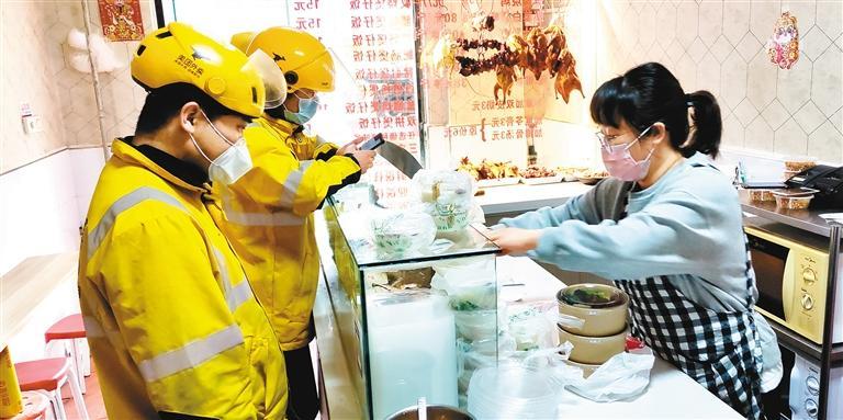 外卖骑手正在李家村一餐馆内排队取餐.  (记者 窦翊明 摄)