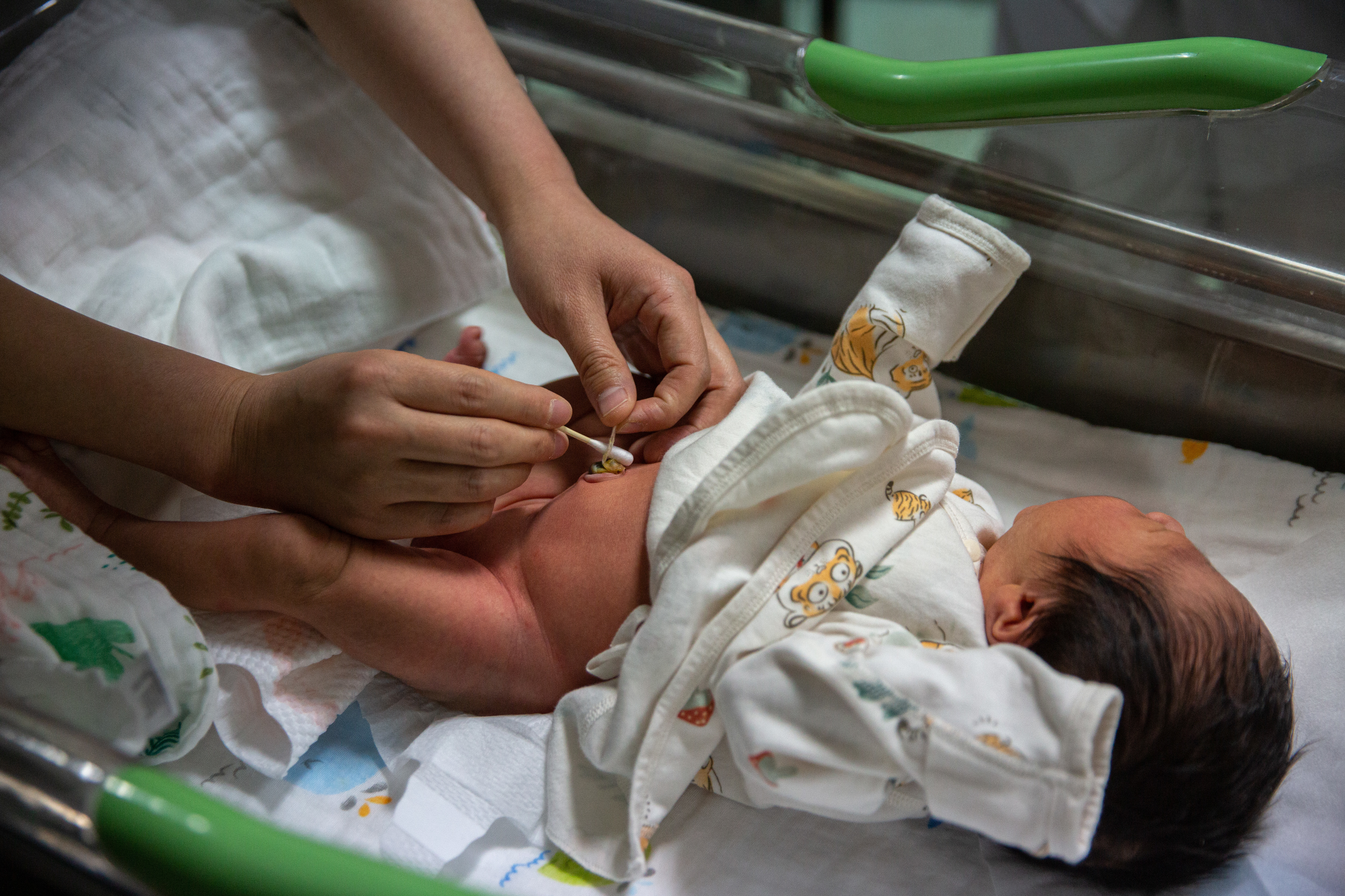5月7日晚，北京大学首钢医院产科病房，护士张胜苗在教年轻的“爸爸妈妈”们为孩子清理肚脐。
