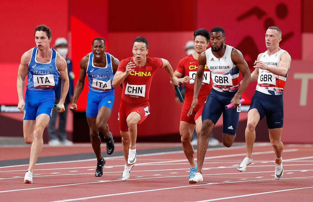 2021年8月6日，东京奥运会田径男子4X100米接力决赛中国队第四棒吴智强和第三棒苏炳添在比赛中。新华社记者王丽莉摄