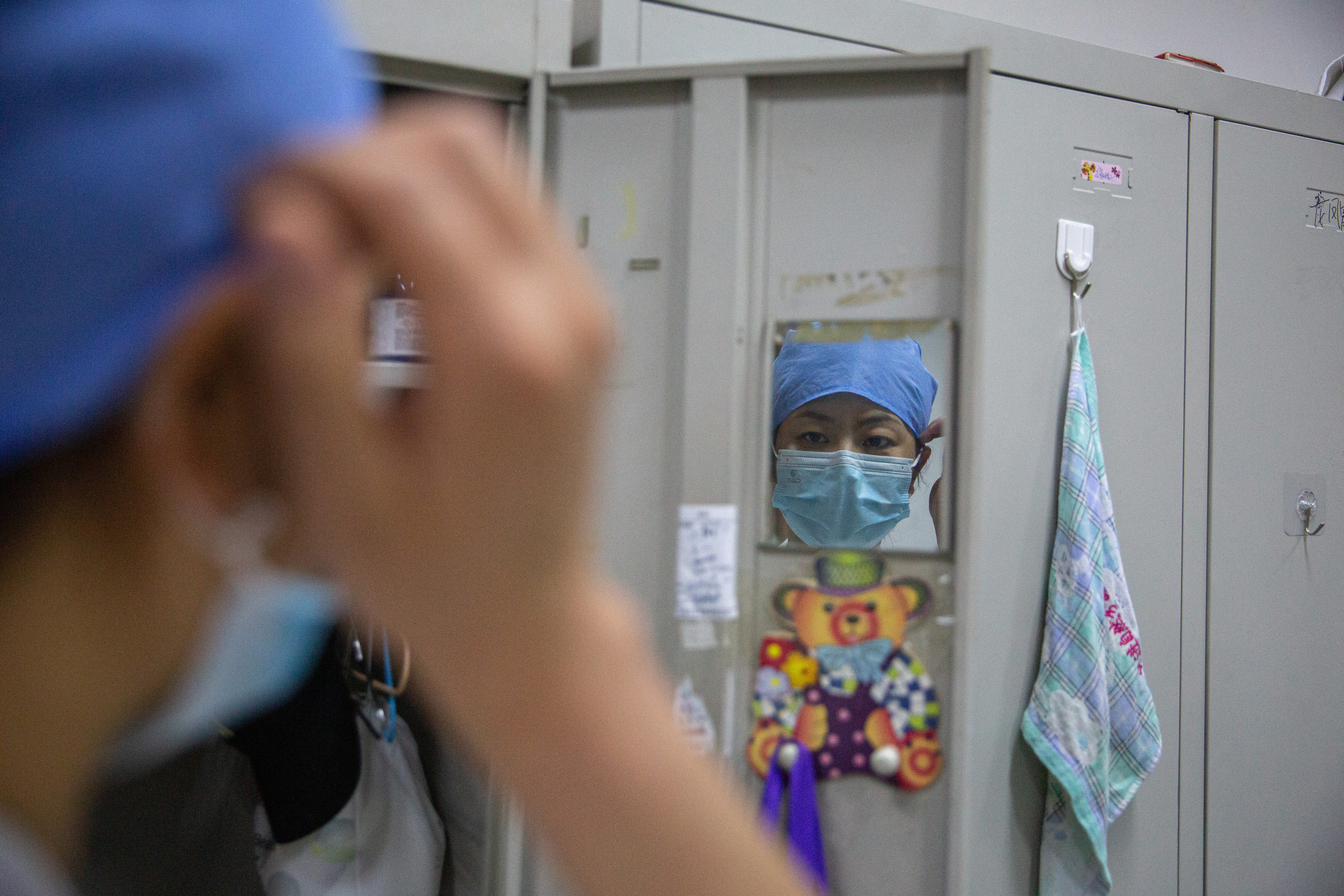 5月7日晚，北京大学首钢医院产科病房，休息时间，护士张胜苗整理衣物和口罩。