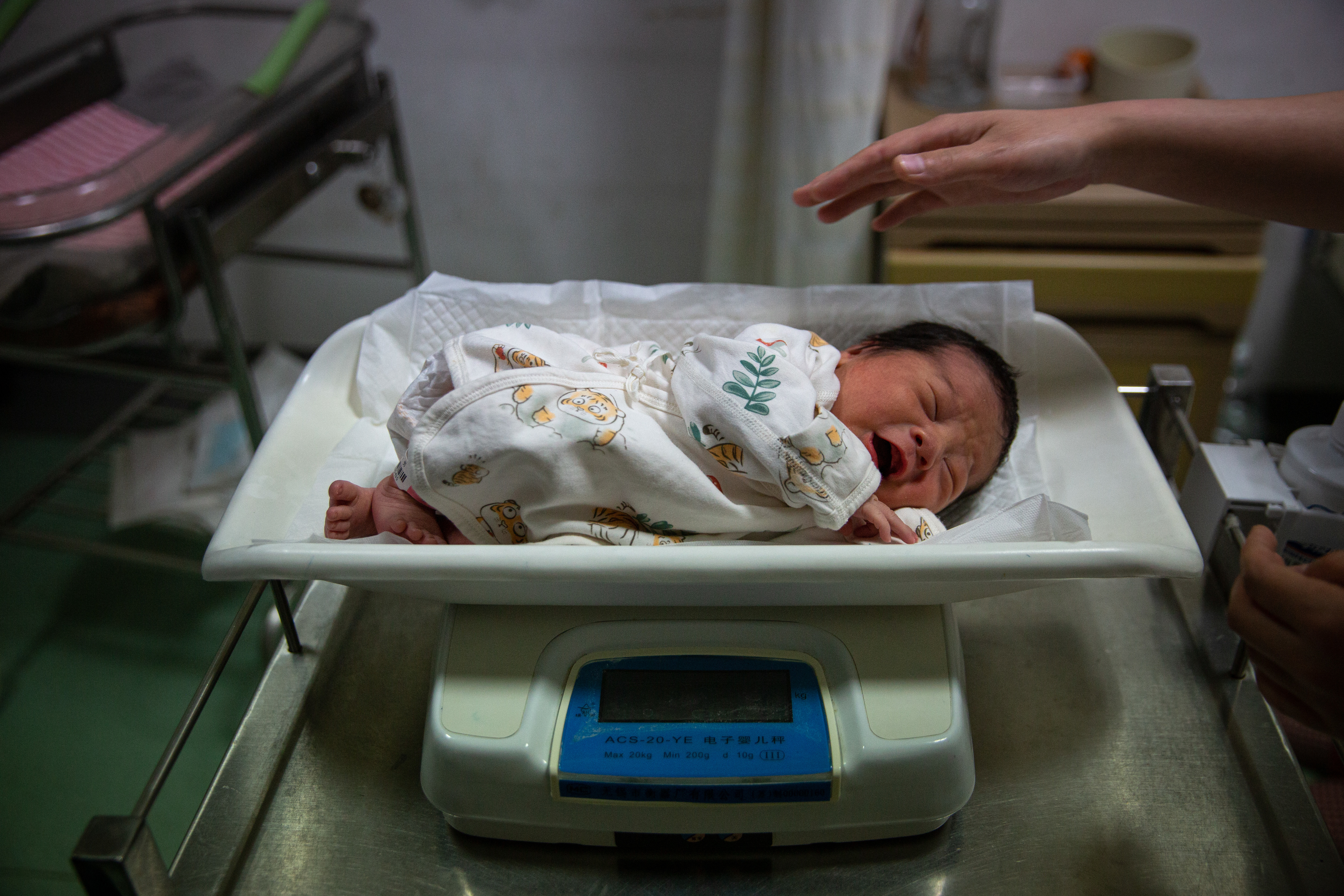 5月7日晚，北京大学首钢医院产科病房，护士为一名新生儿称体重。