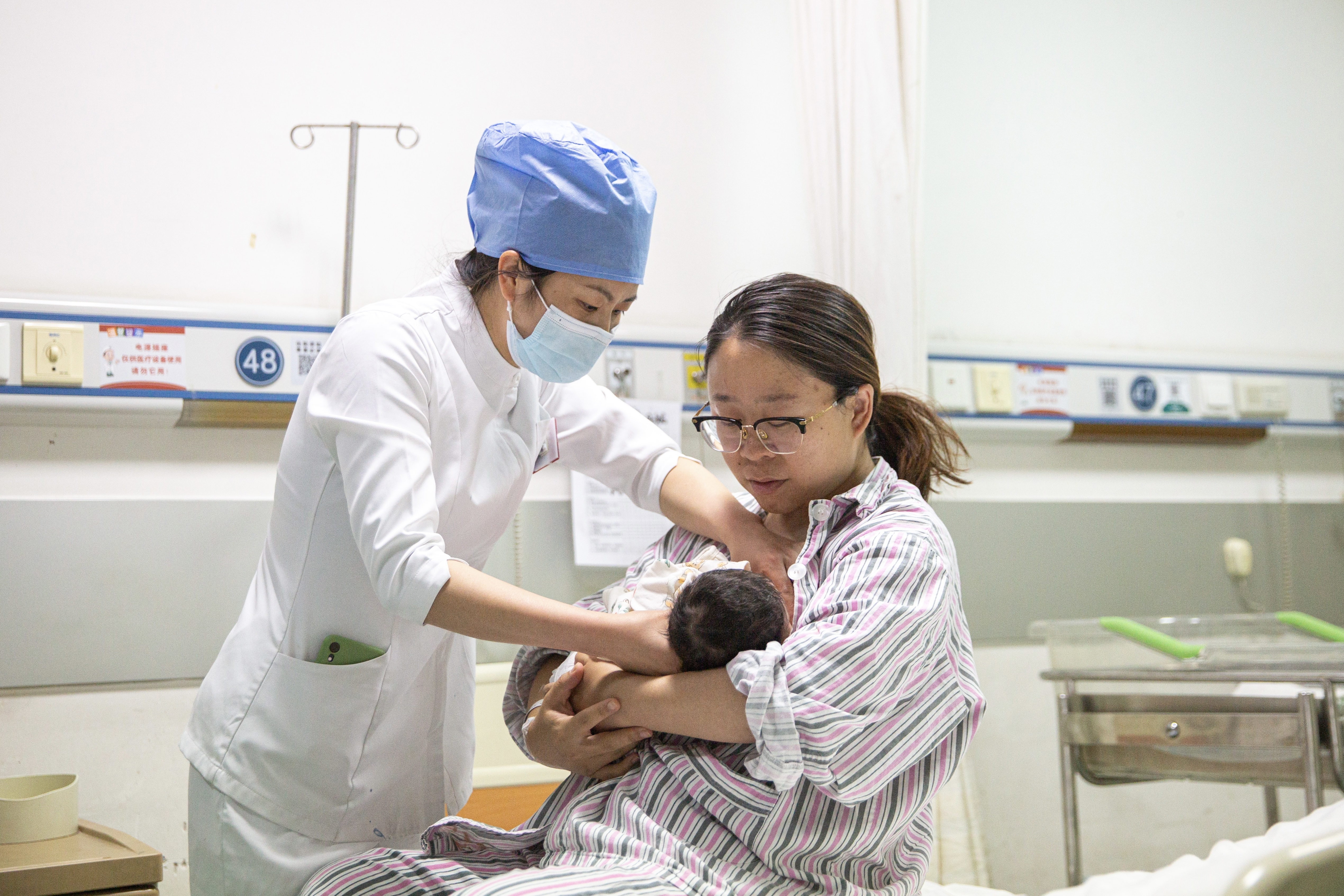 5月7日晚，北京大学首钢医院产科病房，护士张胜苗指导产妇温丹妮哺乳。