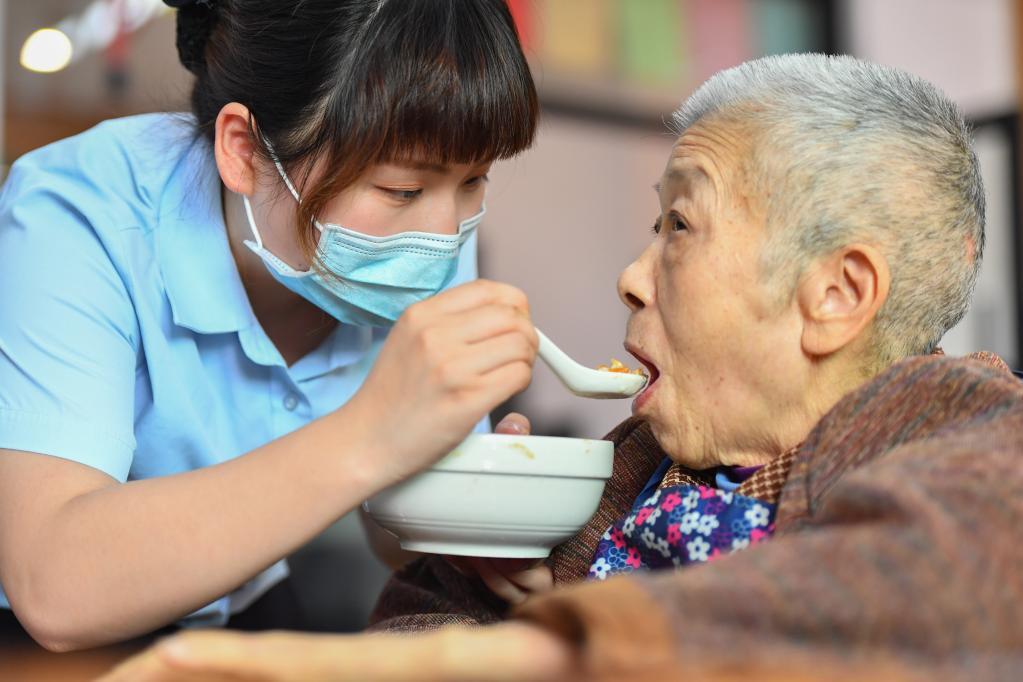 在湖南省湘潭市雨湖区窑湾街道综合养老服务中心，养老护理员喂老人吃午餐（2022年5月17日摄）。新华社记者 陈泽国 摄