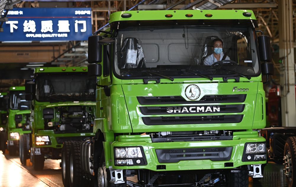 摄5月24日,工人在陕西汽车控股集团有限公司总装车间进行重型卡车装配