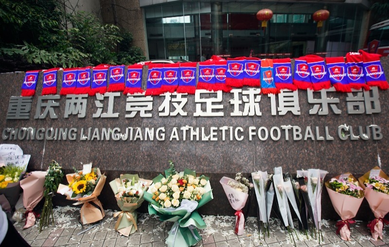 重庆队俱乐部基地球迷送上鲜花和俱乐部围巾