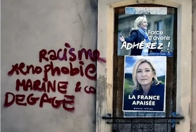 （街头宣传画边上的涂鸦：“种族主义分子，仇外分子，玛丽娜和喽喽们，滚开！”图源：BBC）