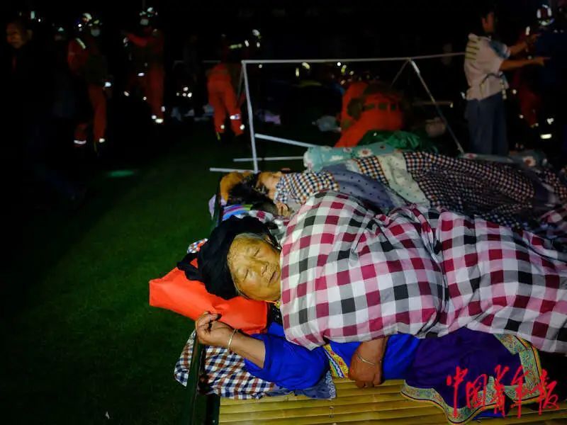6月1日晚，四川雅安宝兴县七一初级中学体育场安置点，一名老人在单人床上合衣而睡。程雪力/摄
