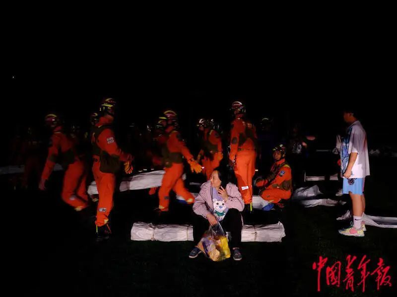 6月1日晚，四川雅安宝兴县七一初级中学体育场安置点，消防员正在运送物资。程雪力/摄