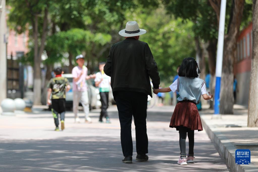 5月17日"爷爷"送然然去上学.新华社记者 杜哲宇 摄