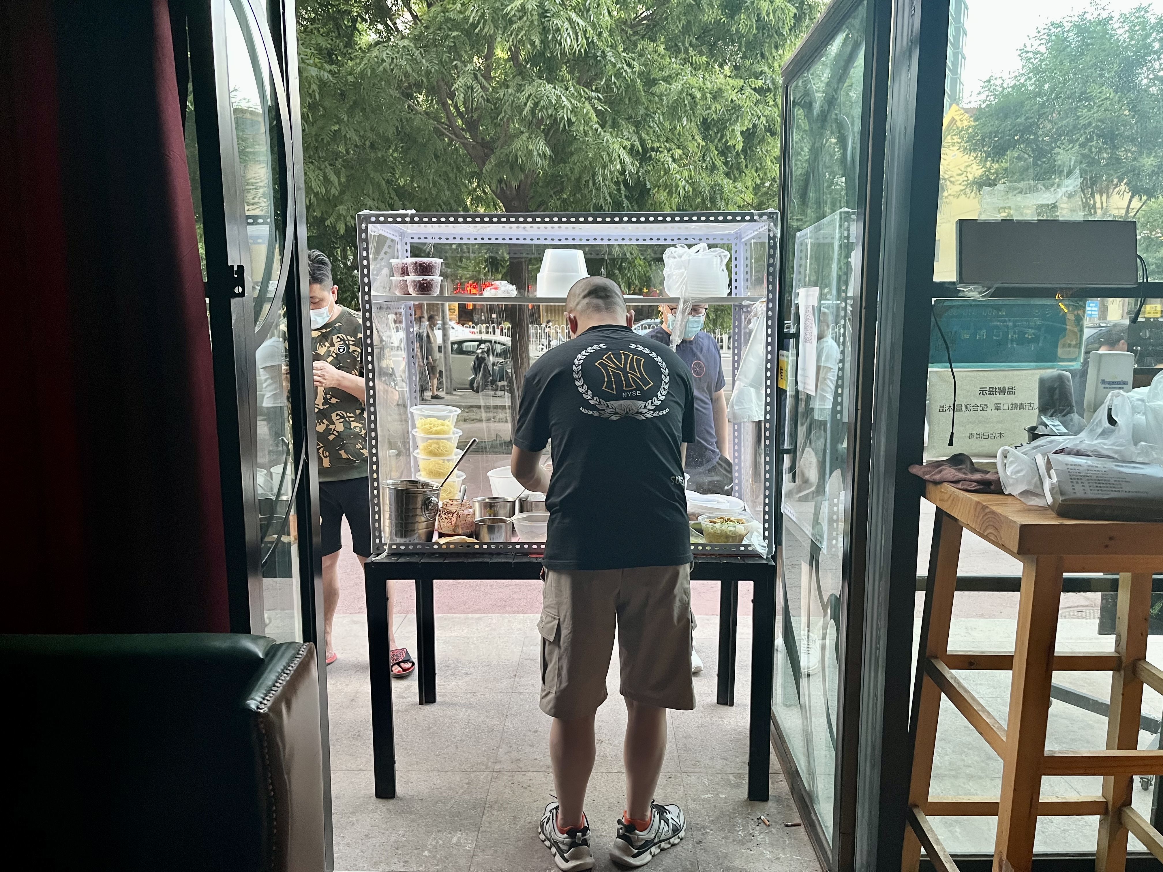 5月25日傍晚，朝阳区青年路，109Bar酒吧老板胡小伟正在摊位拌凉皮。新京报记者 吴淋姝 摄