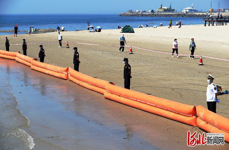 海事清污人员使用充气式围油栏，保护沙滩清洁。 通讯员魏伟摄