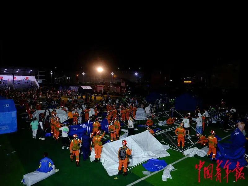 6月1日晚，四川雅安宝兴县七一初级中学体育场安置点，消防员与当地群众一起搭建帐篷。程雪力/摄