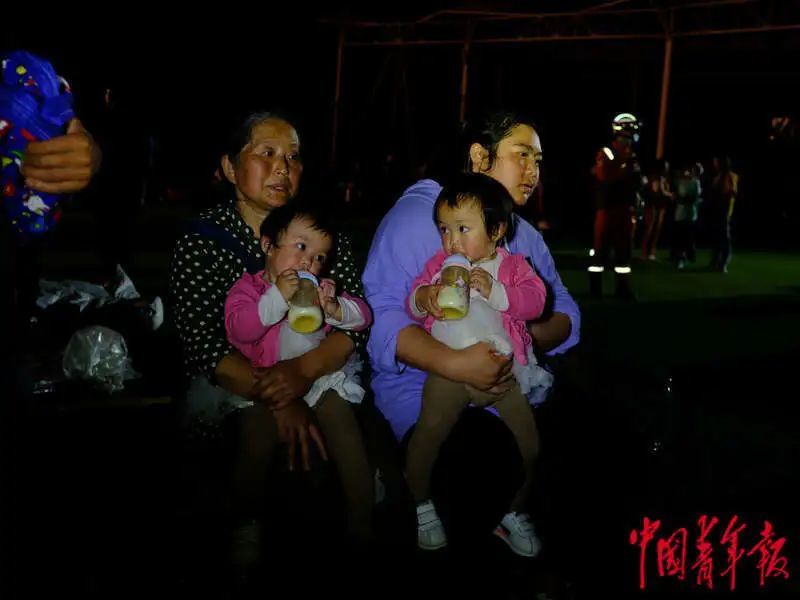 6月1日晚，四川雅安宝兴县七一初级中学体育场安置点，一对正在喝奶的双胞胎。程雪力/摄