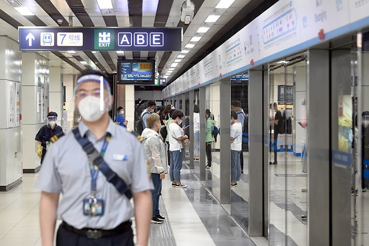 地铁10号线双井站，工作人员维持秩序的同时做好防护。